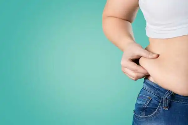 Image of woman pinching her love handles to show weight gain Little Bognor